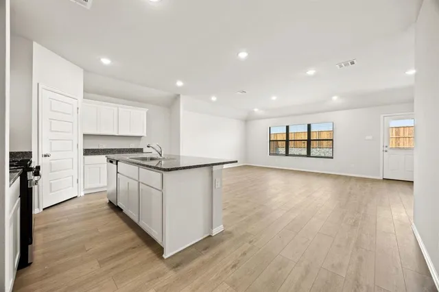 a kitchen with stainless steel appliances granite countertop a stove a sink and a refrigerator