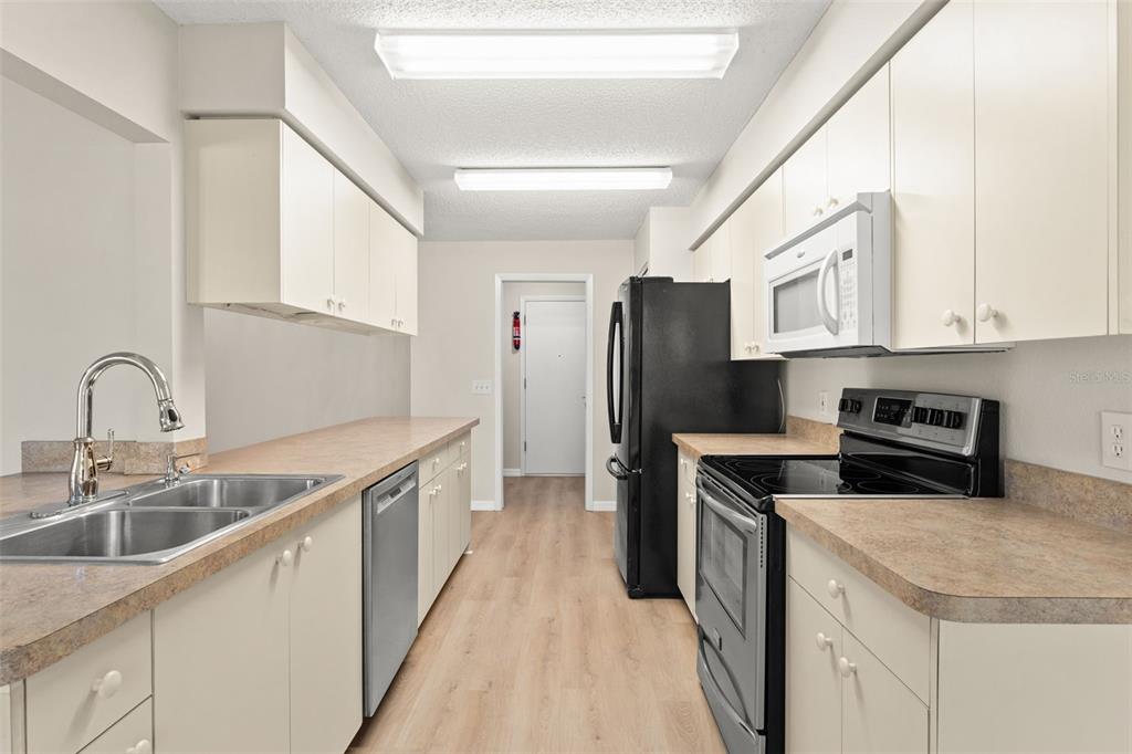 1415 Pinewood Hills Court Spring Hill, FL 34606 - Photo 20 of 45 a kitchen with stainless steel appliances granite countertop a sink stove and refrigerator