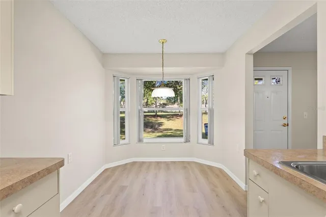 a view of an empty room with window and cabinet