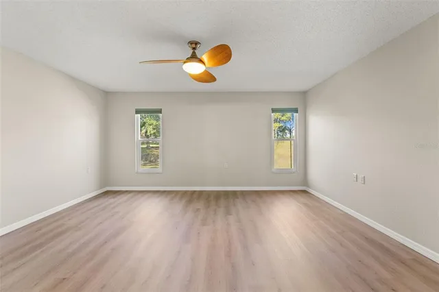 an empty room with wooden floor and window