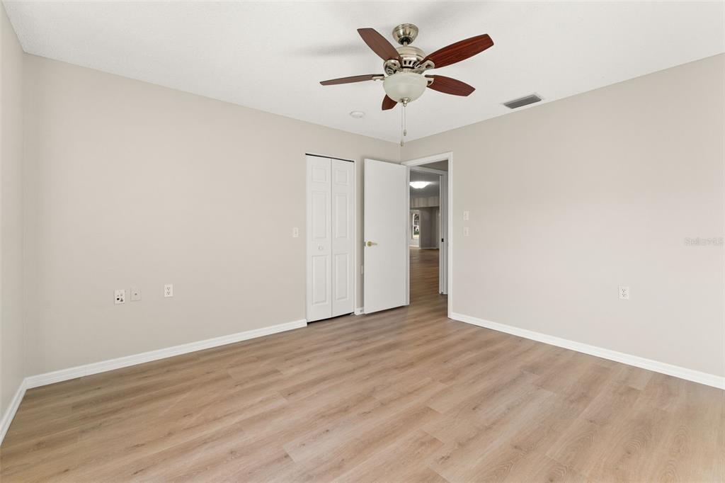 1415 Pinewood Hills Court Spring Hill, FL 34606 - Photo 28 of 45 an empty room with wooden floor and ceiling fan