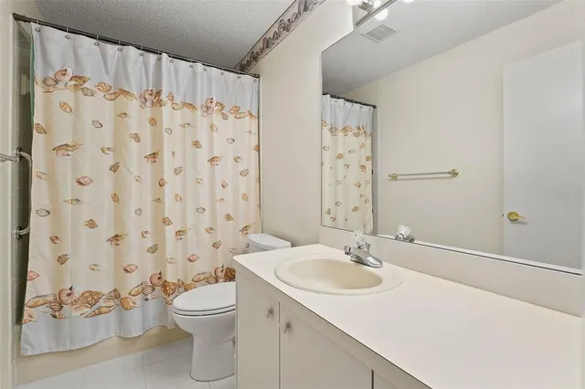 a bathroom with a sink a toilet and shower curtain