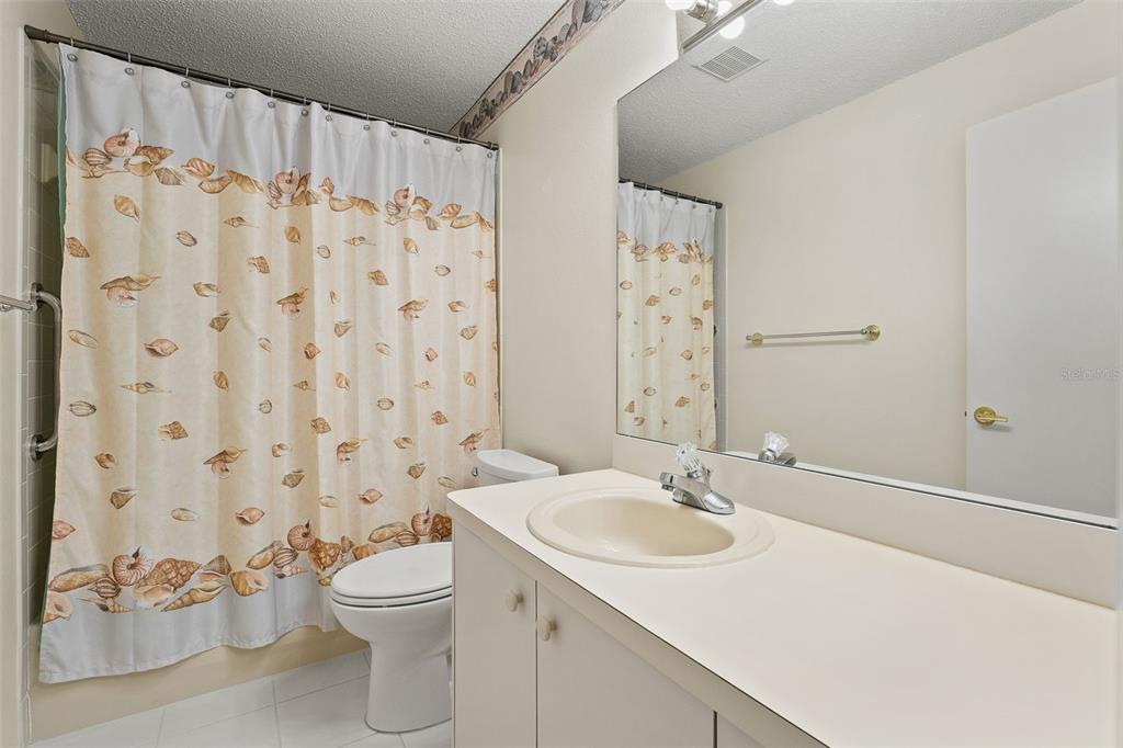1415 Pinewood Hills Court Spring Hill, FL 34606 - Photo 31 of 45 a bathroom with a sink a toilet and shower curtain