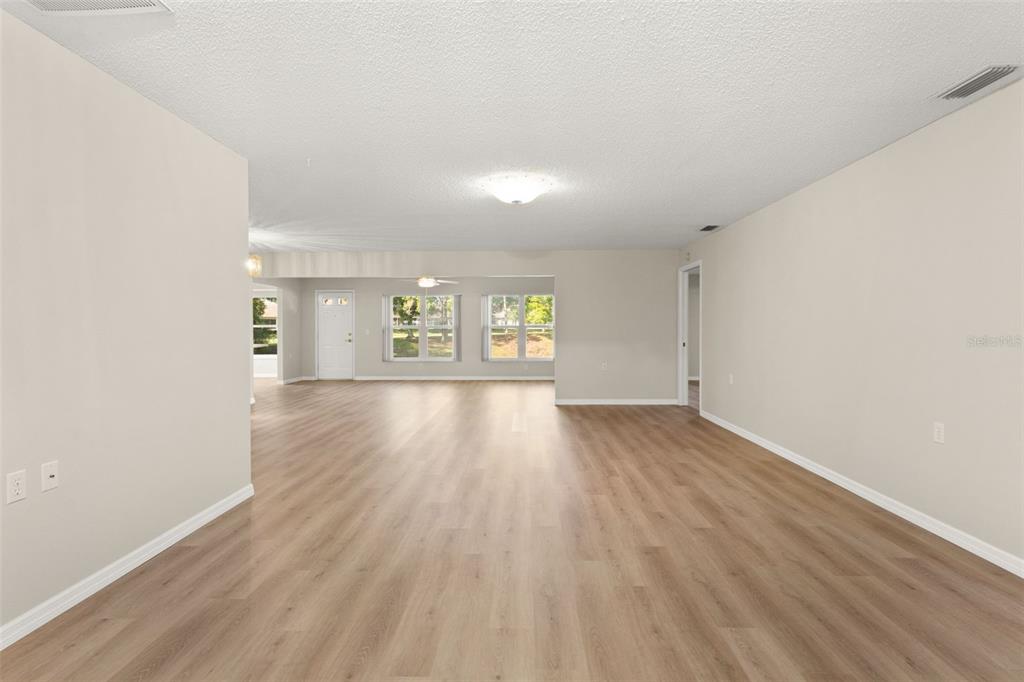 1415 Pinewood Hills Court Spring Hill, FL 34606 - Photo 8 of 45 wooden floor in an empty room with a window
