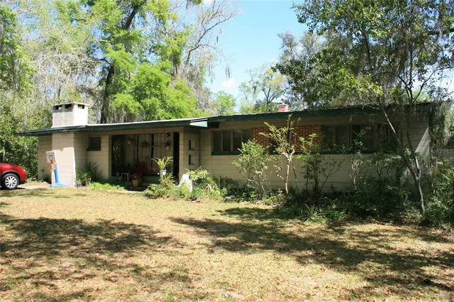 a view of a house with a tree in front of it