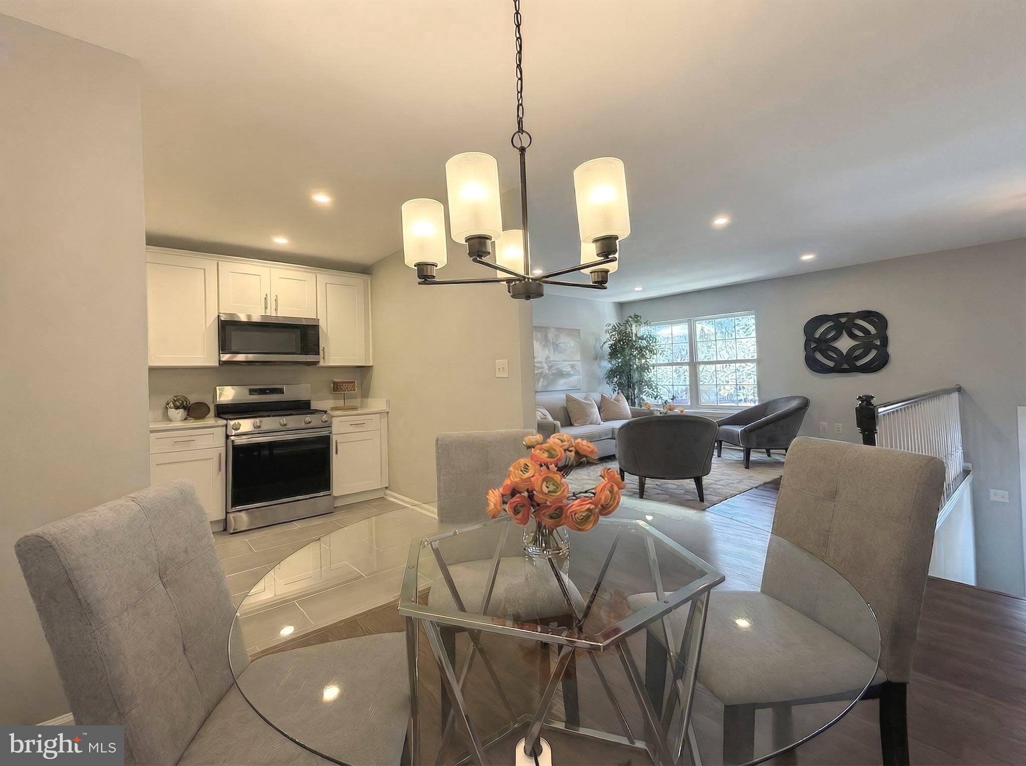 205 Castleton Court Pennington, NJ 08534 - Photo 6 of 26 a kitchen with stainless steel appliances kitchen island granite countertop a stove a sink a dining table and chairs with wooden floor