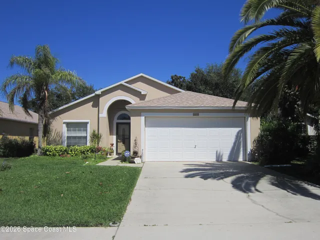 a front view of a house with a garden and yard