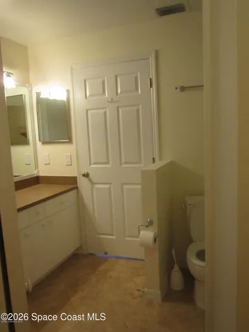 a bathroom with a granite countertop sink a toilet and mirror