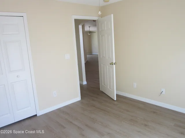 an empty room with wooden floor and closet