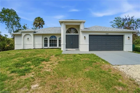 a front view of a house with yard and garage