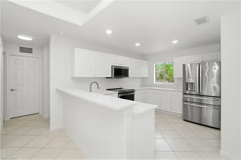 a kitchen with stainless steel appliances a refrigerator sink and microwave