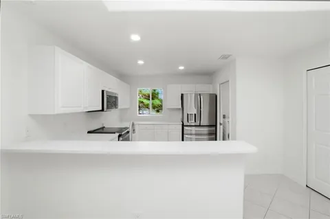 a view of kitchen with stainless steel appliances a sink and a refrigerator