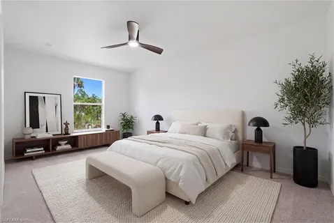 a bedroom with a large bed couch and a window