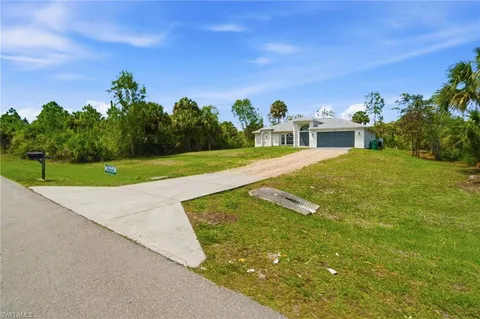 a view of a house with a yard and basketball court