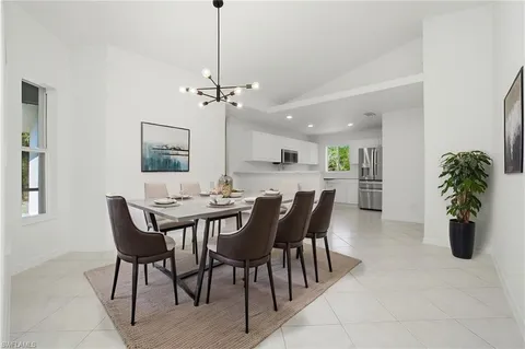 a view of a dining room and livingroom with furniture wooden floor a chandelier