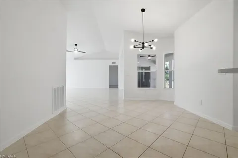 a view of a hallway with windows and chandelier