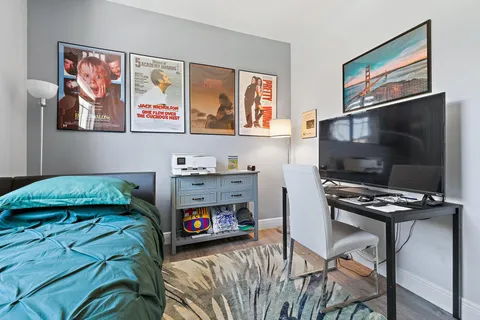 a bedroom with furniture and a flat screen tv