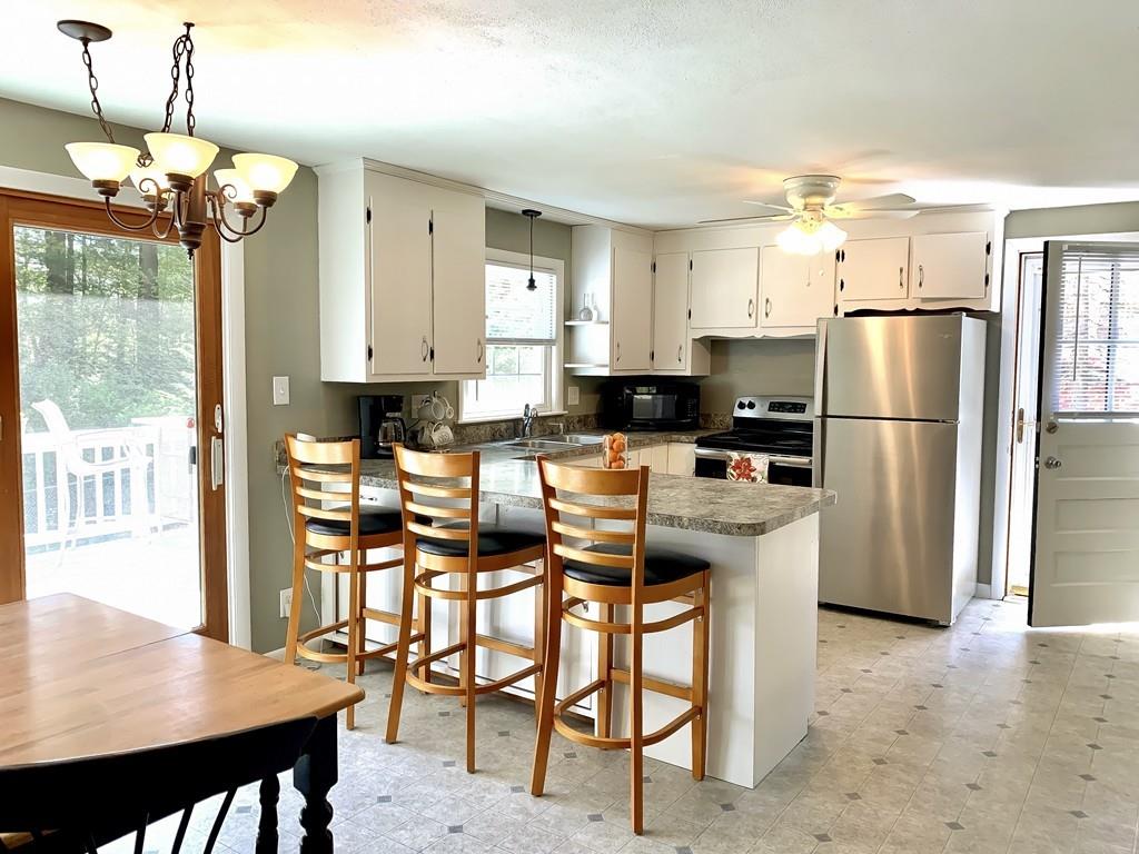 411 Dwight Road East Longmeadow, MA 01028 - Photo 5 of 34 a kitchen with stainless steel appliances granite countertop a stove a refrigerator a sink a dining table and chairs with wooden floor