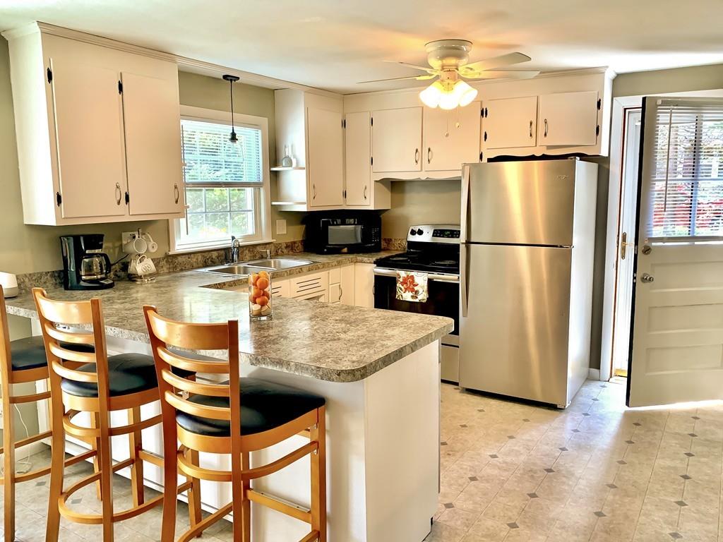 411 Dwight Road East Longmeadow, MA 01028 - Photo 6 of 34 a kitchen with stainless steel appliances granite countertop a refrigerator a stove a sink dishwasher and white cabinets with wooden floor