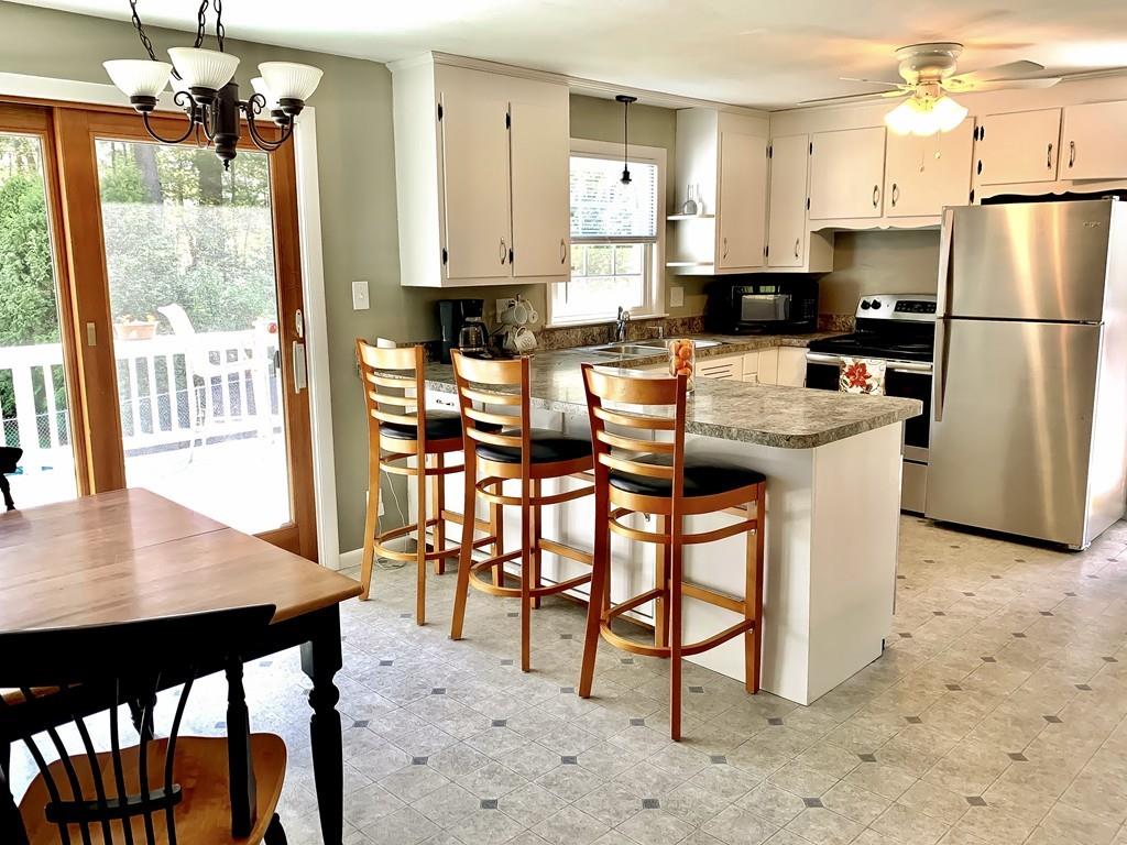 411 Dwight Road East Longmeadow, MA 01028 - Photo 8 of 34 a kitchen with stainless steel appliances kitchen island granite countertop a table chairs and a refrigerator