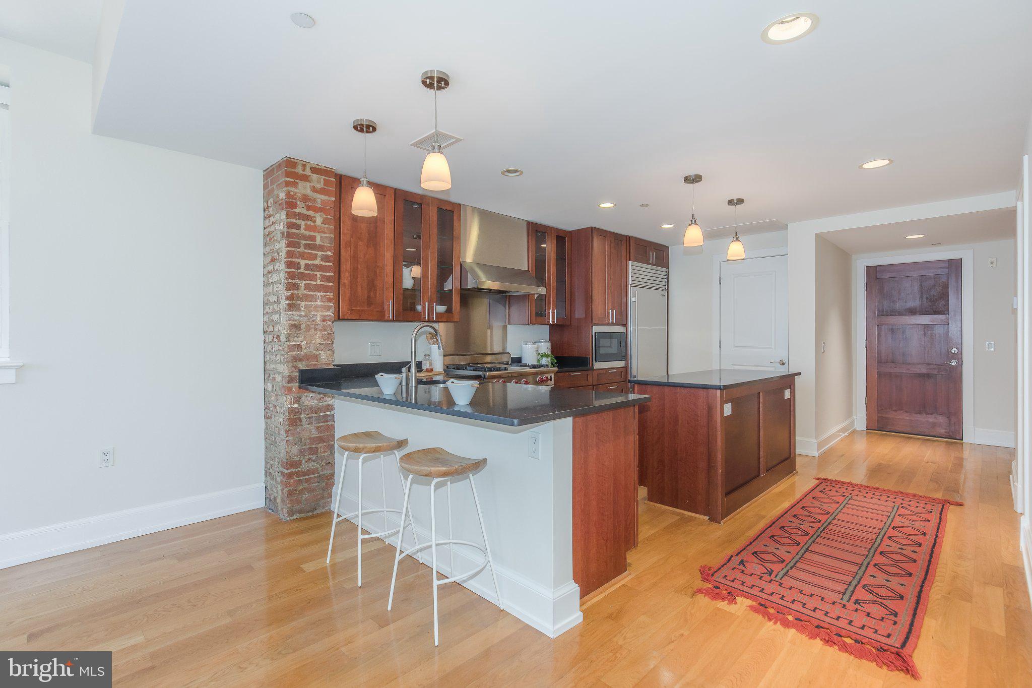215 I Street Northeast, Unit 105 Washington, DC 20002 - Photo 15 of 41 a kitchen with stainless steel appliances granite countertop a sink and a refrigerator