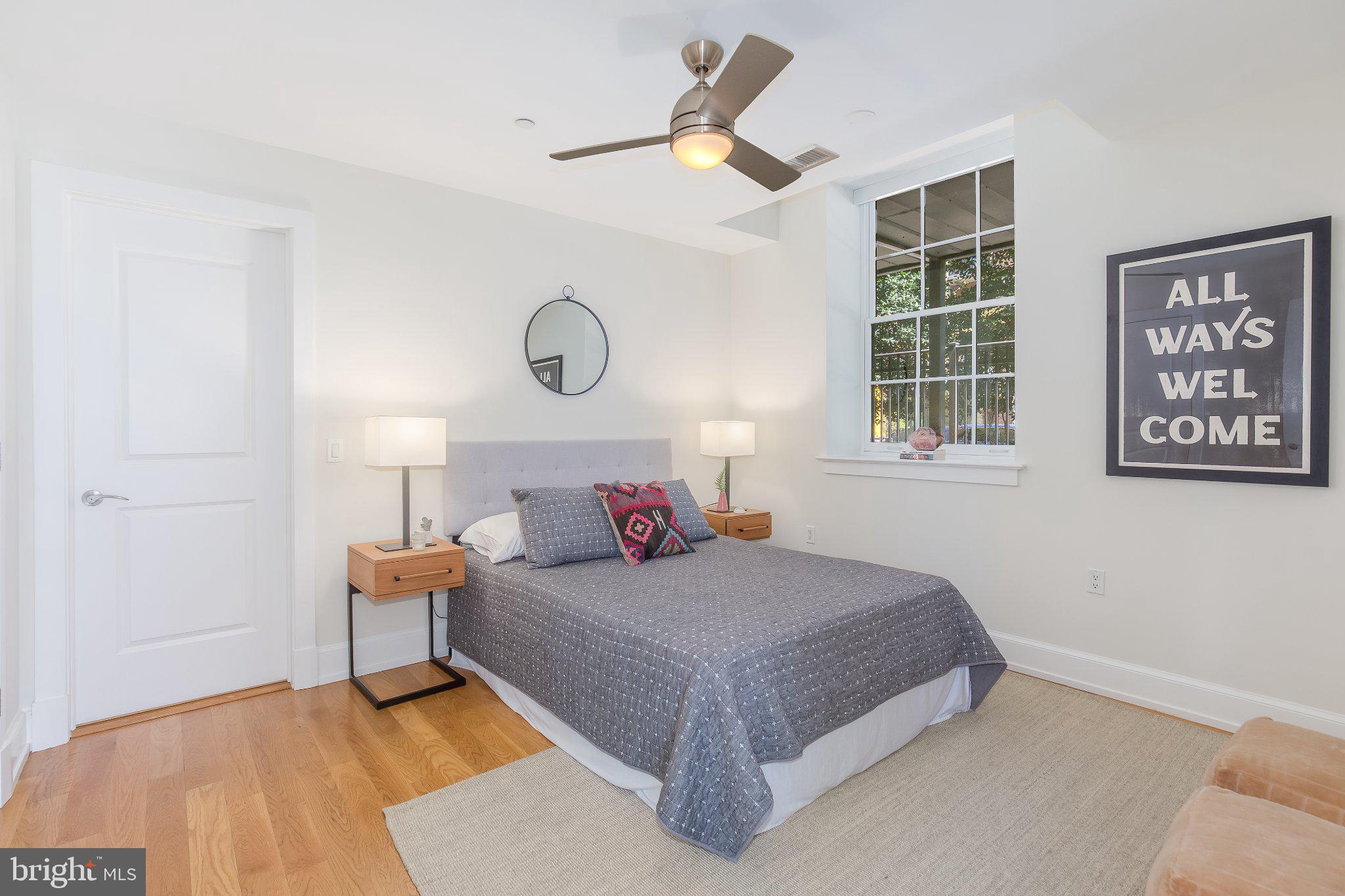 215 I Street Northeast, Unit 105 Washington, DC 20002 - Photo 19 of 41 a bedroom with a large bed and a chandelier