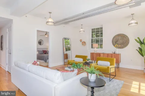 a living room with furniture a chandelier and a window