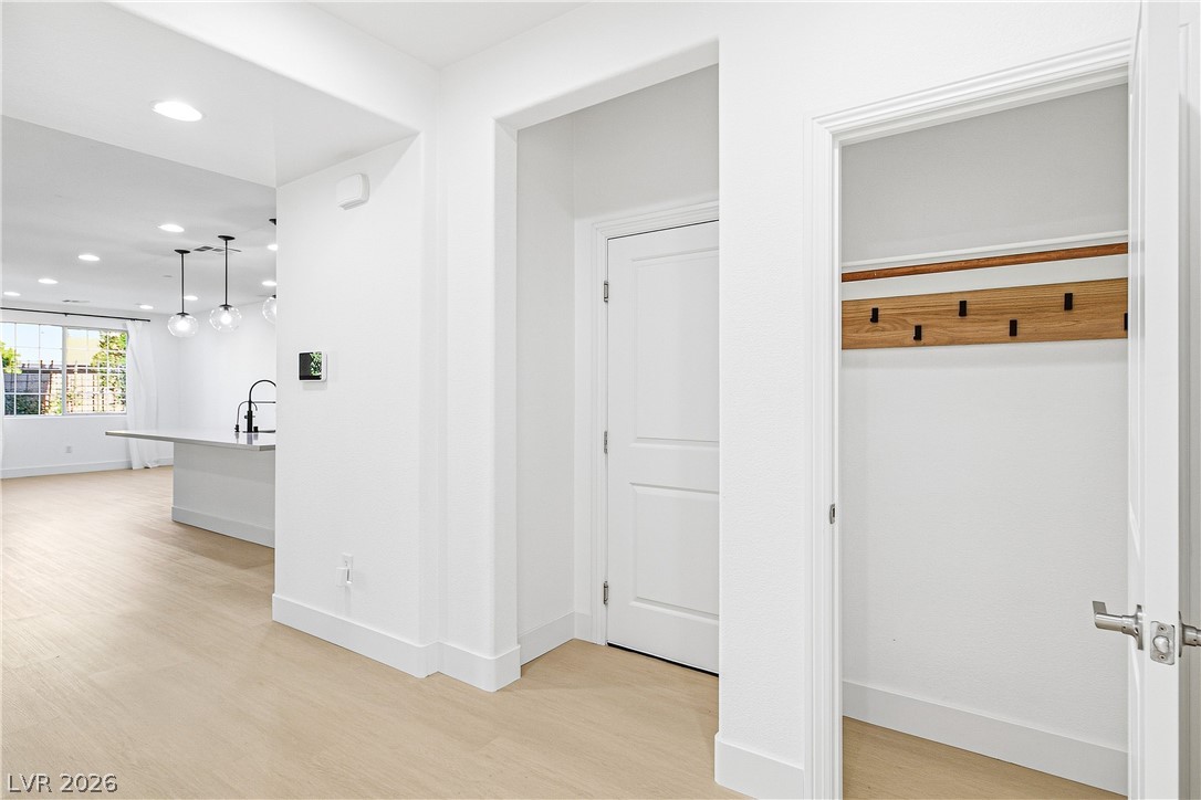 2182 Trivero Street Henderson, NV 89044 - Photo 7 of 50 Crisp white walls and light wood flooring define this bright, open entrance hallway.