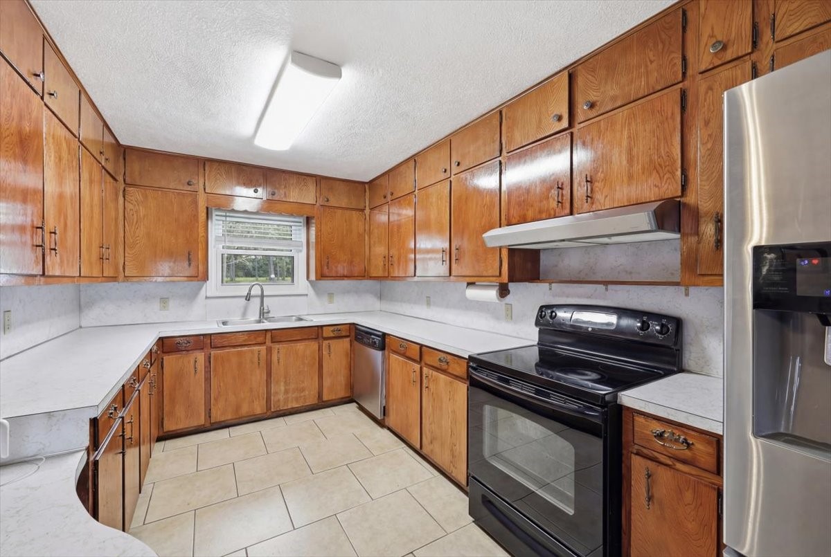 134 Meneley Road Winnie, TX 77665 - Photo 18 of 42 a kitchen with granite countertop a sink a stove and cabinets