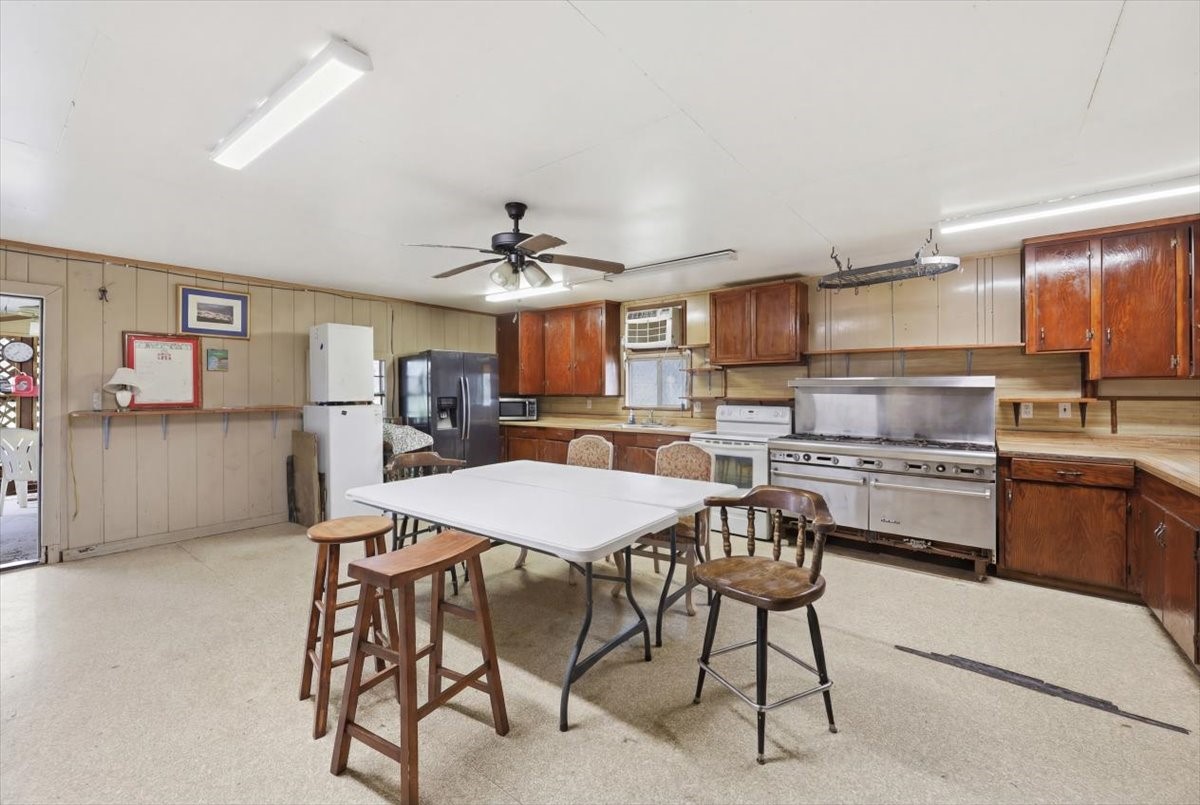 134 Meneley Road Winnie, TX 77665 - Photo 21 of 42 a kitchen with kitchen island a stove a table and chairs in it