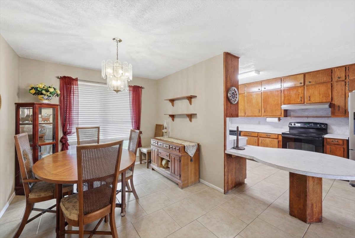 134 Meneley Road Winnie, TX 77665 - Photo 23 of 42 a kitchen with stainless steel appliances kitchen island granite countertop a table chairs and a refrigerator