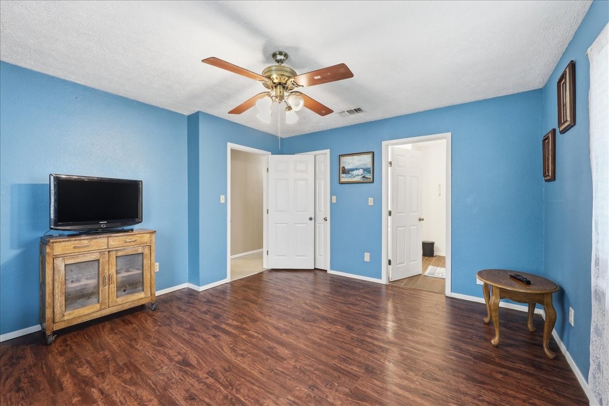 134 Meneley Road Winnie, TX 77665 - Photo 35 of 42 a view of a livingroom with a flat screen tv wooden floor and a ceiling fan