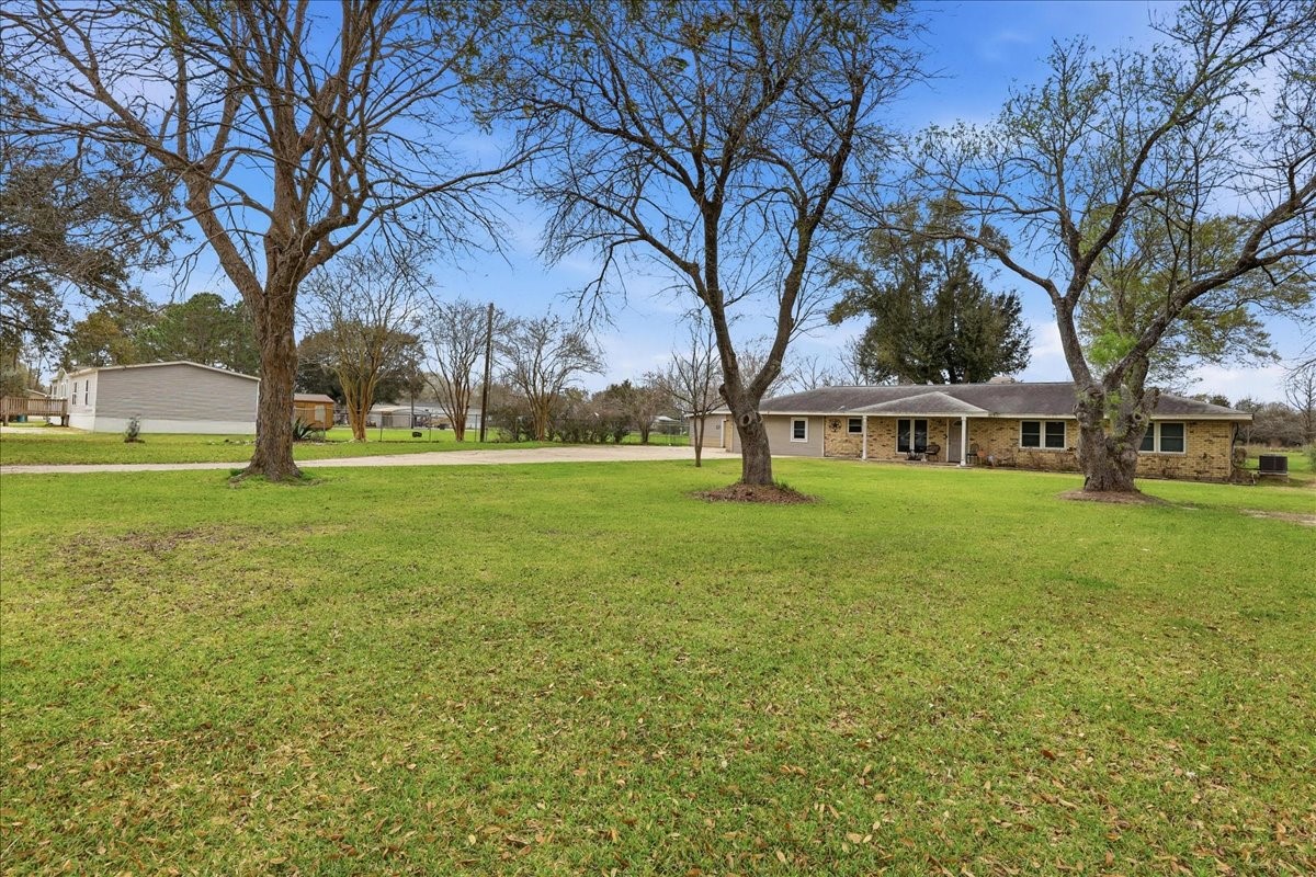 134 Meneley Road Winnie, TX 77665 - Photo 10 of 42 a yellow house with trees in front of it