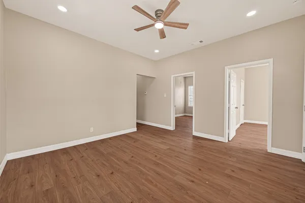 an empty room with wooden floor and windows