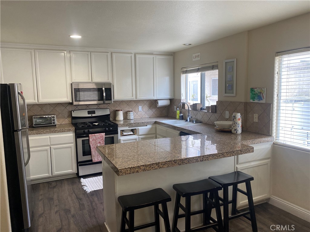 620 4th Street Hermosa Beach, CA 90254 - Photo 4 of 9 a kitchen with kitchen island granite countertop a sink a counter space appliances and windows