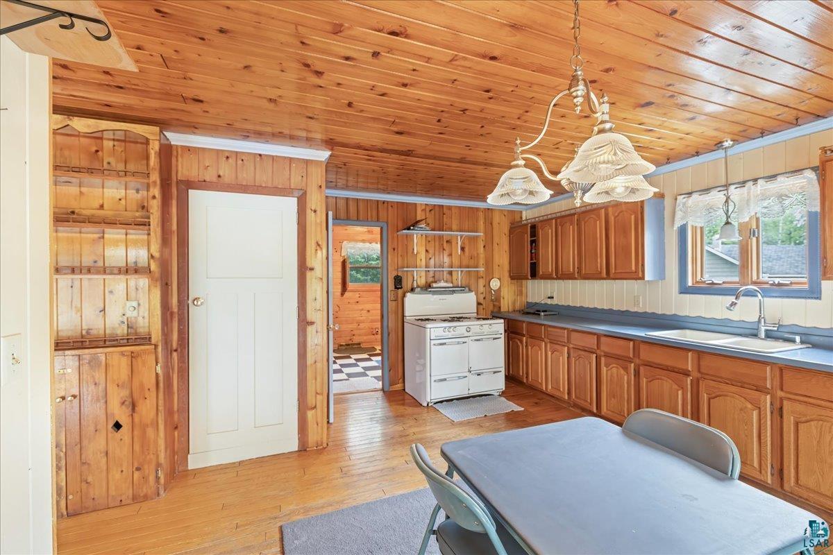 1804 North Bay Road Ely, MN 55731 - Photo 5 of 37 Kitchen featuring wood ceiling, sink, wood walls, and light hardwood / wood-style floors