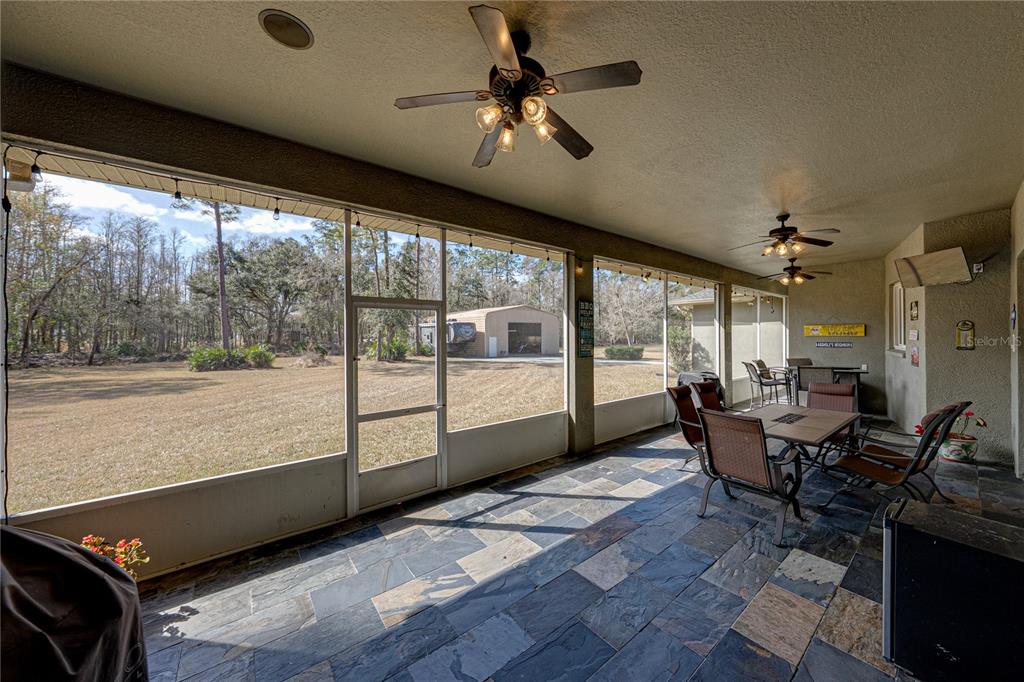 27154 Raven Brook Road Wesley Chapel, FL 33544 - Photo 48 of 65 a living room with furniture and a floor to ceiling window