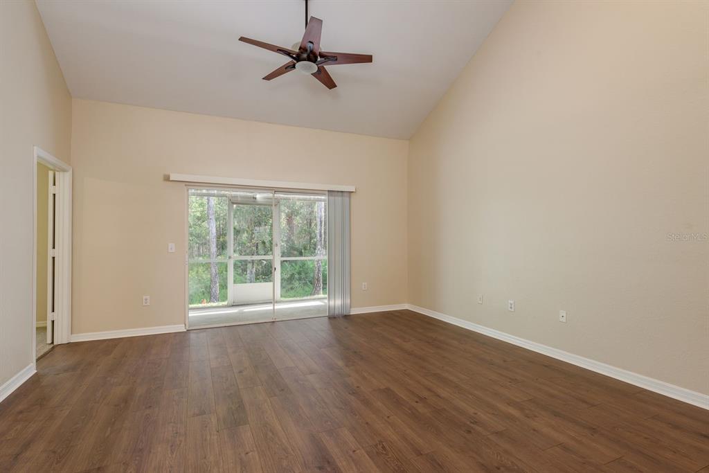 3521 Kings Road, Unit 102 Palm Harbor, FL 34685 - Photo 12 of 50 a view of an empty room with wooden floor and a window