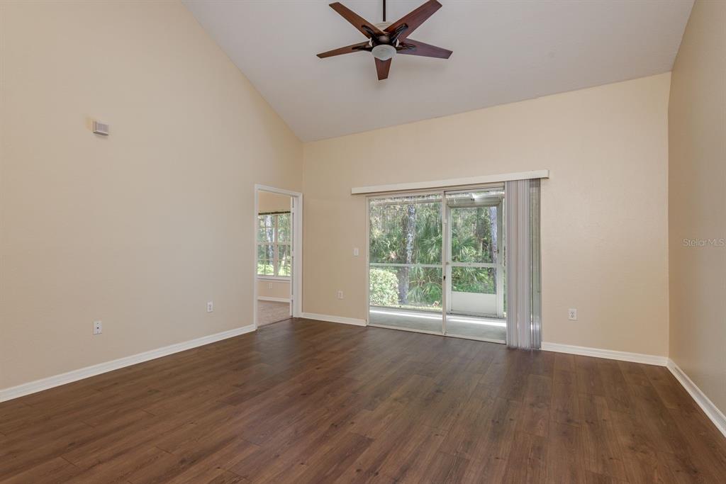 3521 Kings Road, Unit 102 Palm Harbor, FL 34685 - Photo 13 of 50 a view of an empty room with wooden floor and a window
