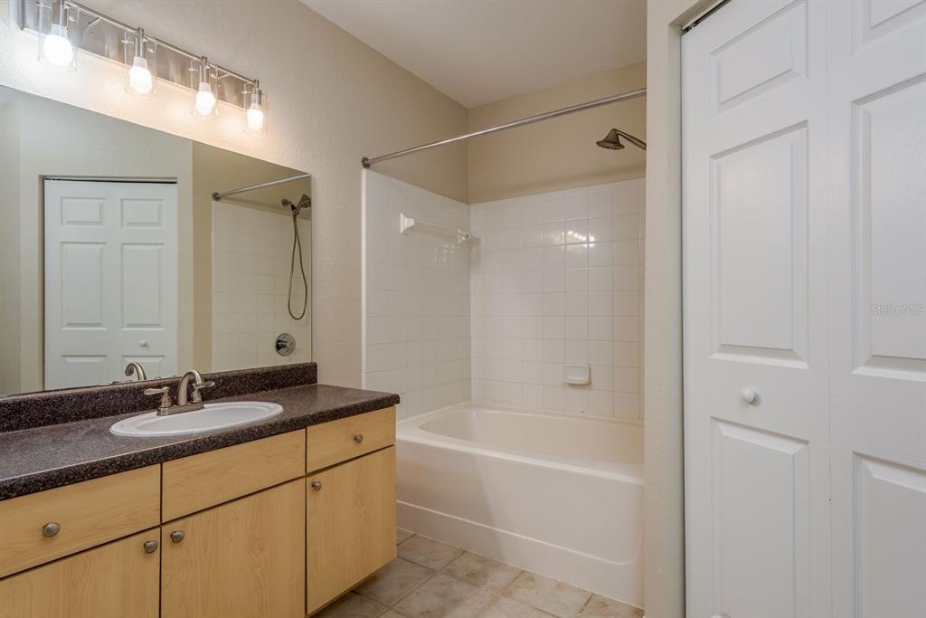 3521 Kings Road, Unit 102 Palm Harbor, FL 34685 - Photo 16 of 50 a bathroom with a granite countertop sink a mirror and a bathtub