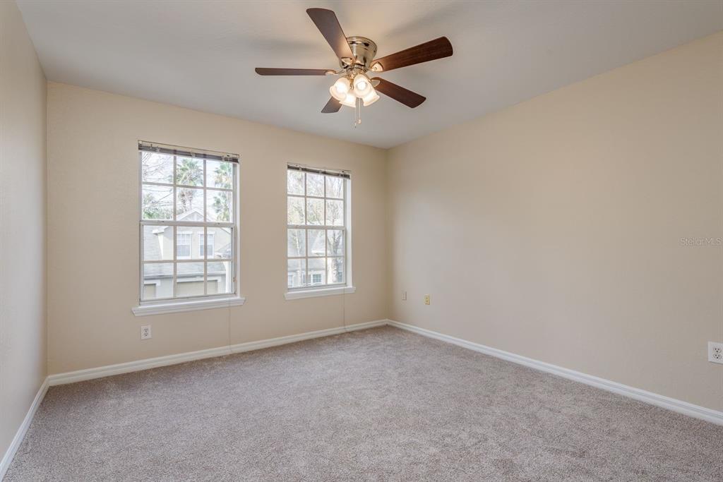 3521 Kings Road, Unit 102 Palm Harbor, FL 34685 - Photo 23 of 50 an empty room with chandelier fan and windows