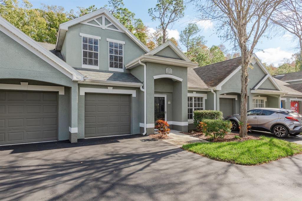 3521 Kings Road, Unit 102 Palm Harbor, FL 34685 - Photo 3 of 50 a front view of a house with a yard and garage