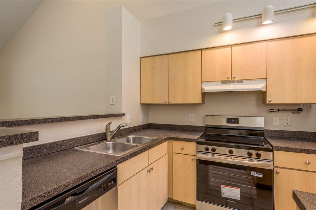 3521 Kings Road, Unit 102 Palm Harbor, FL 34685 - Photo 9 of 50 a kitchen with granite countertop a sink a stove and cabinets