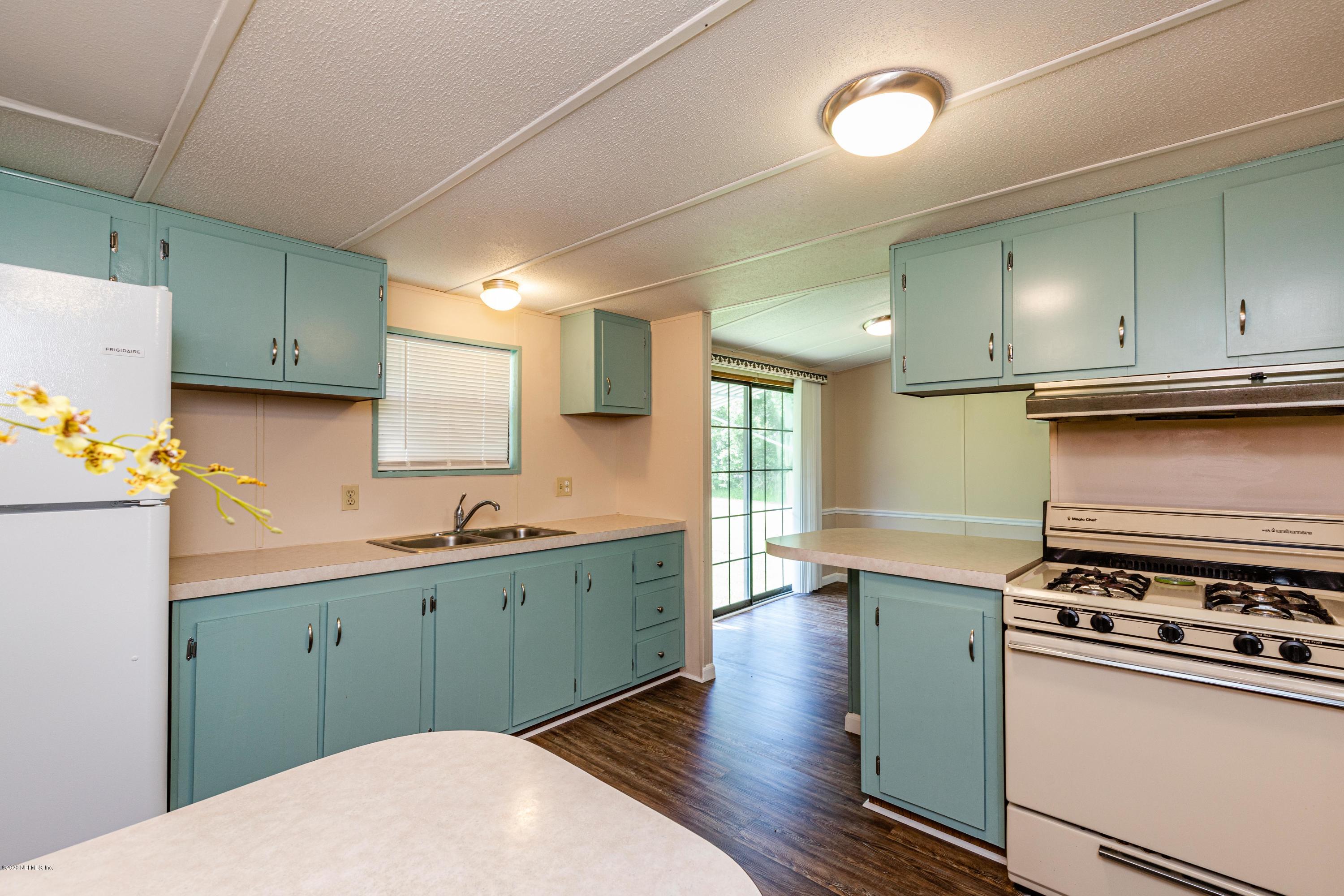 54537 Armstrong Road Callahan, FL 32011 - Photo 13 of 49 a kitchen with stainless steel appliances a stove a sink wooden cabinets and a refrigerator