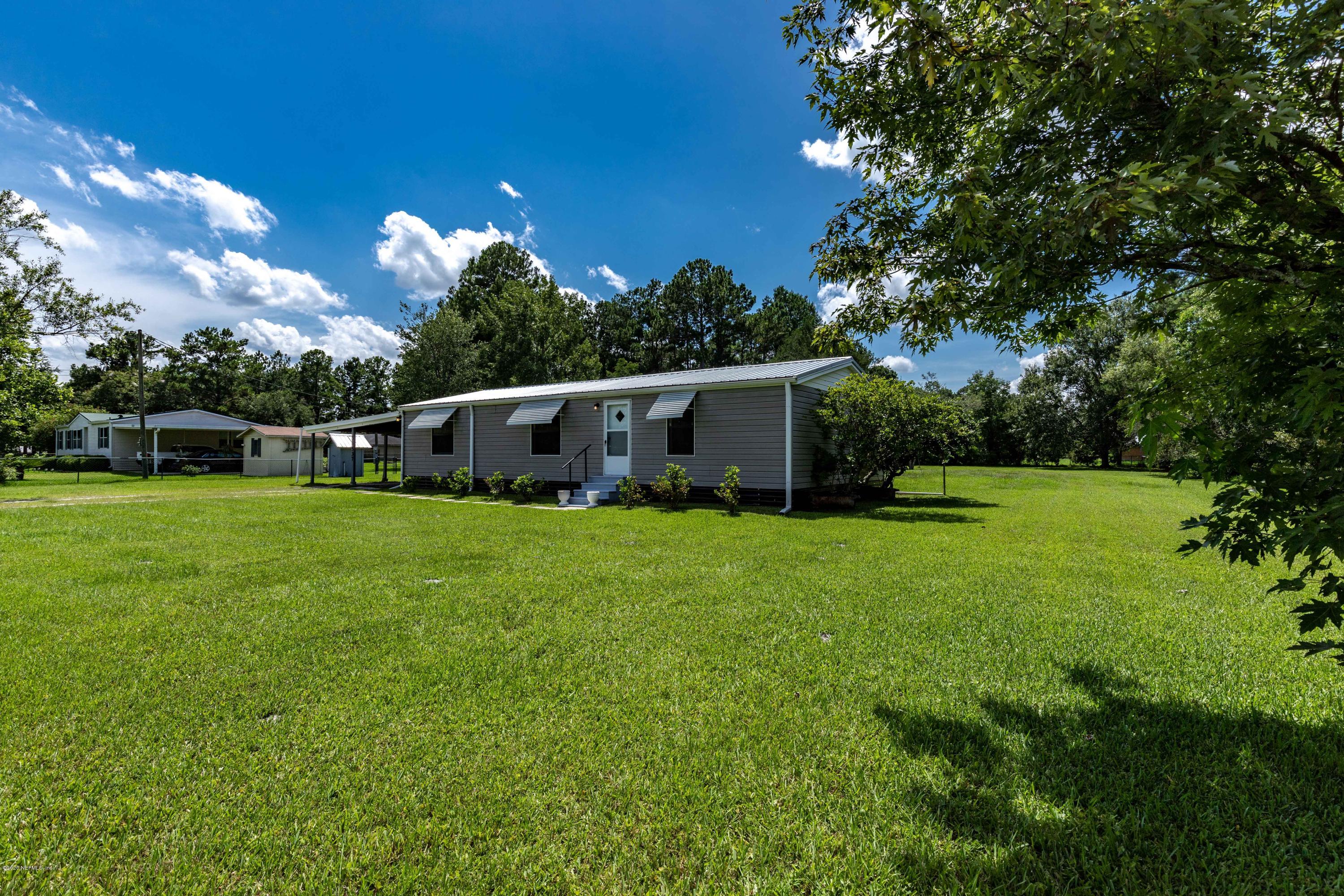 54537 Armstrong Road Callahan, FL 32011 - Photo 38 of 49 a front view of a house with garden and trees