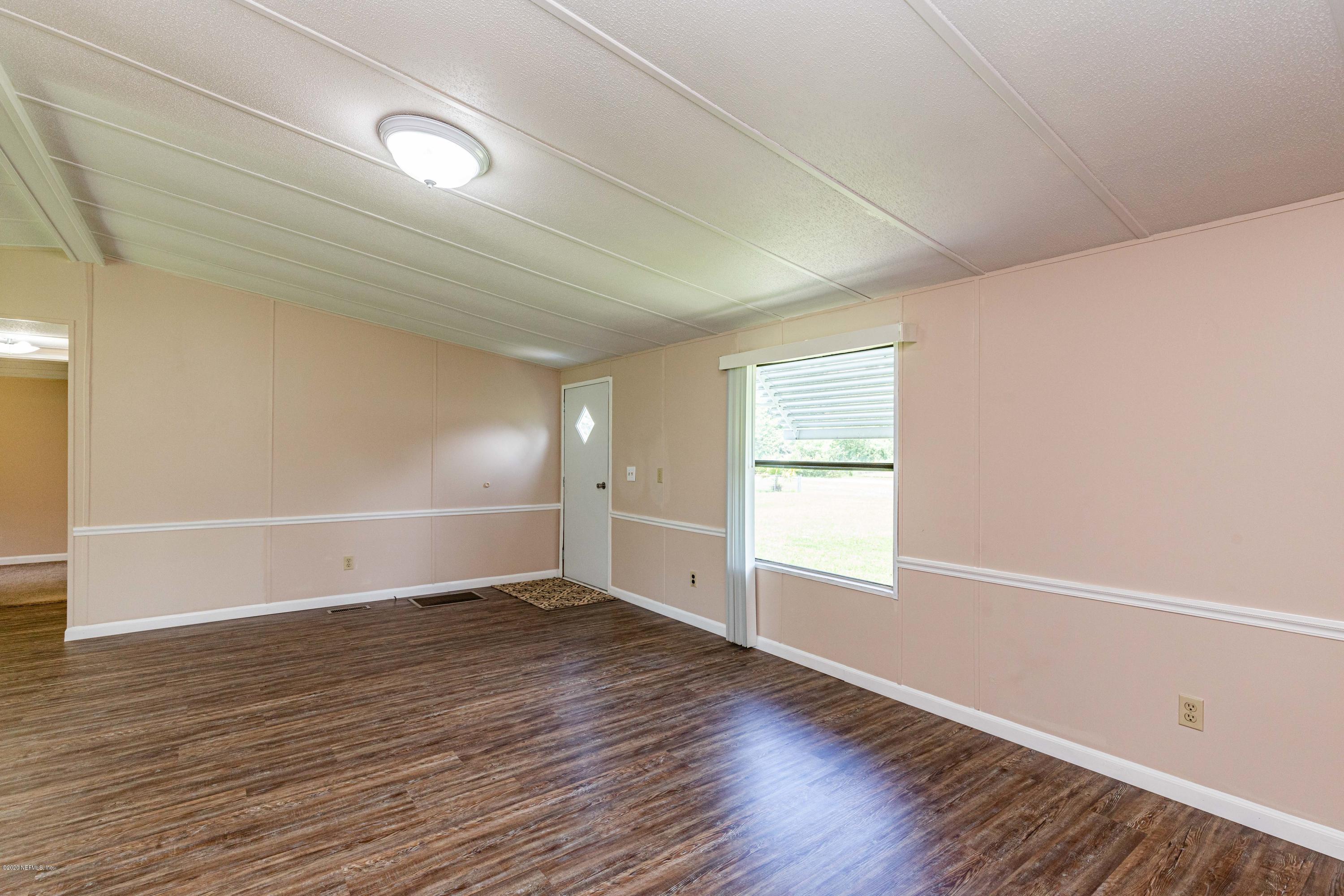 54537 Armstrong Road Callahan, FL 32011 - Photo 6 of 49 an empty room with wooden floor and windows