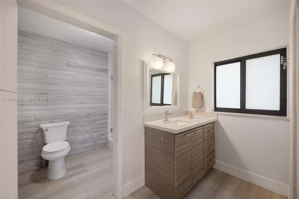 a bathroom with a toilet sink and mirror