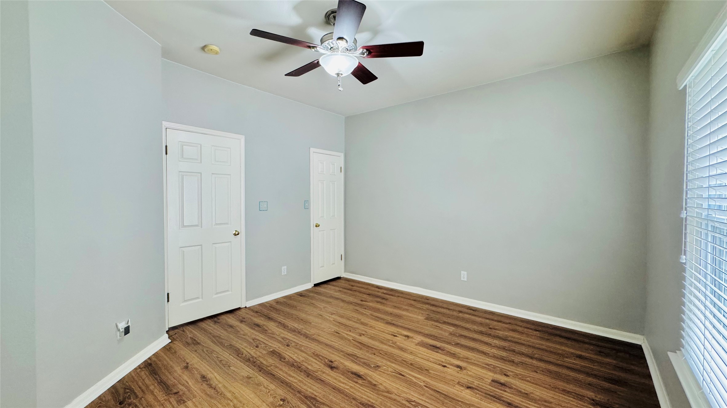 401 Witte Road Kyle, TX 78640 - Photo 6 of 9 Bedroom 2-A versatile room featuring wood flooring and a refreshing ceiling fan.