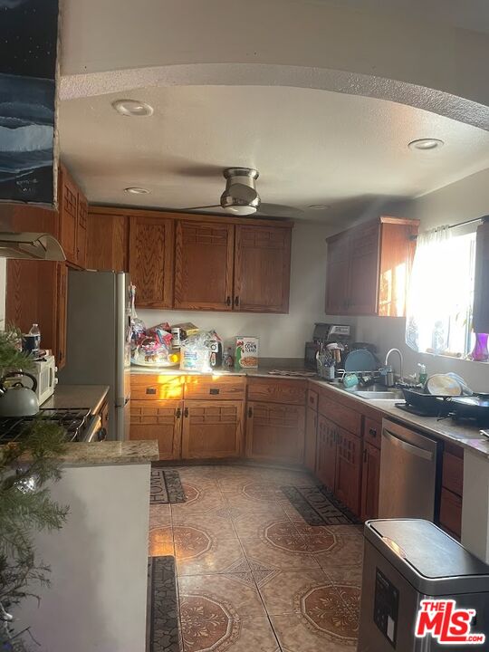 6908 Geyser Avenue Reseda, CA 91335 - Photo 3 of 6 a kitchen with stainless steel appliances granite countertop a sink stove and cabinets