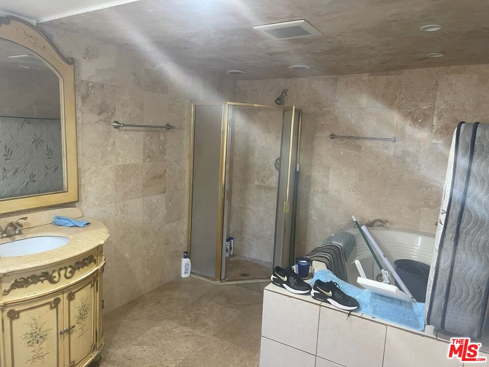 6908 Geyser Avenue Reseda, CA 91335 - Photo 4 of 6 a bathroom with a granite countertop sink a mirror and a shower